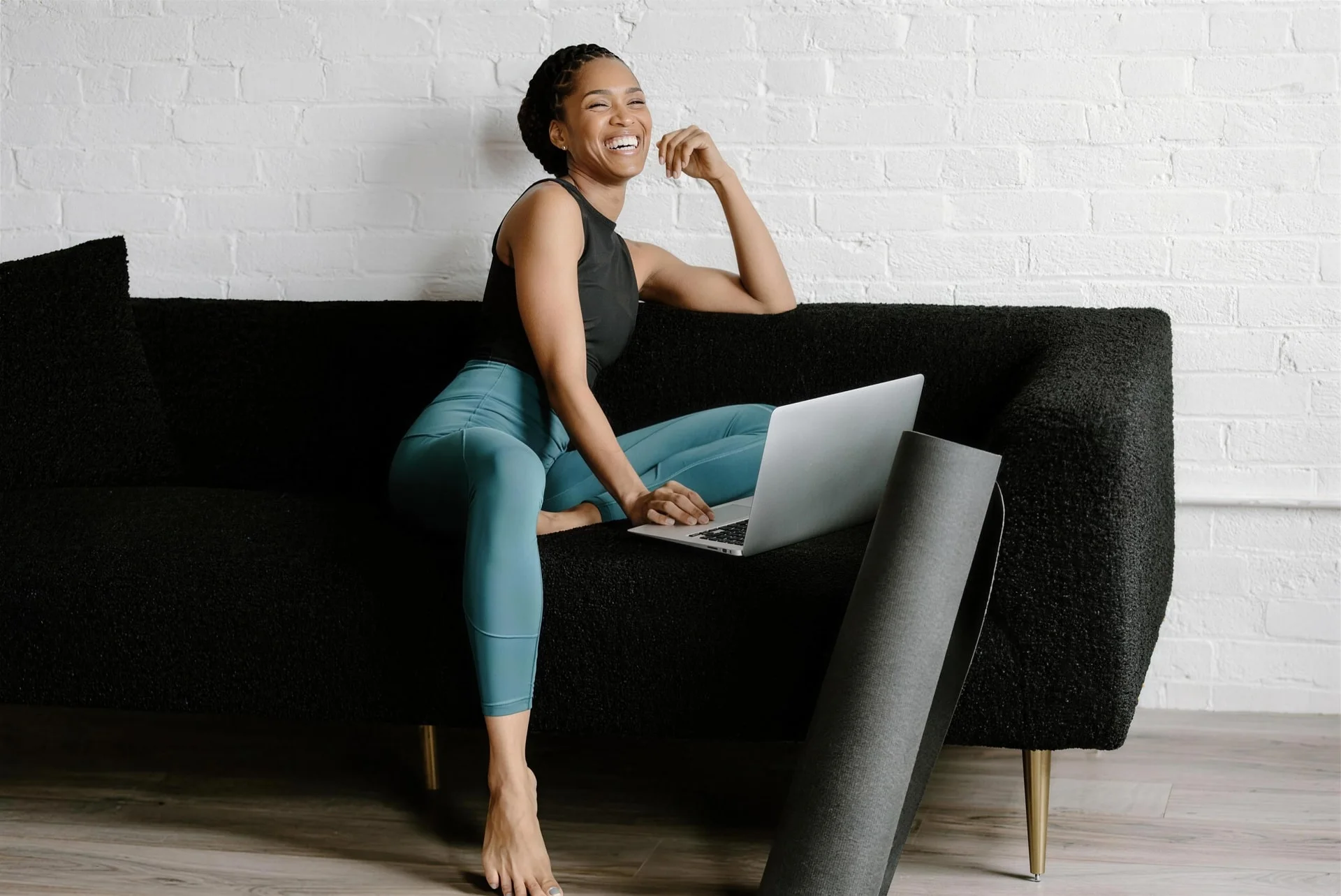 Kimmel Alcide laughing on a couch with her laptop