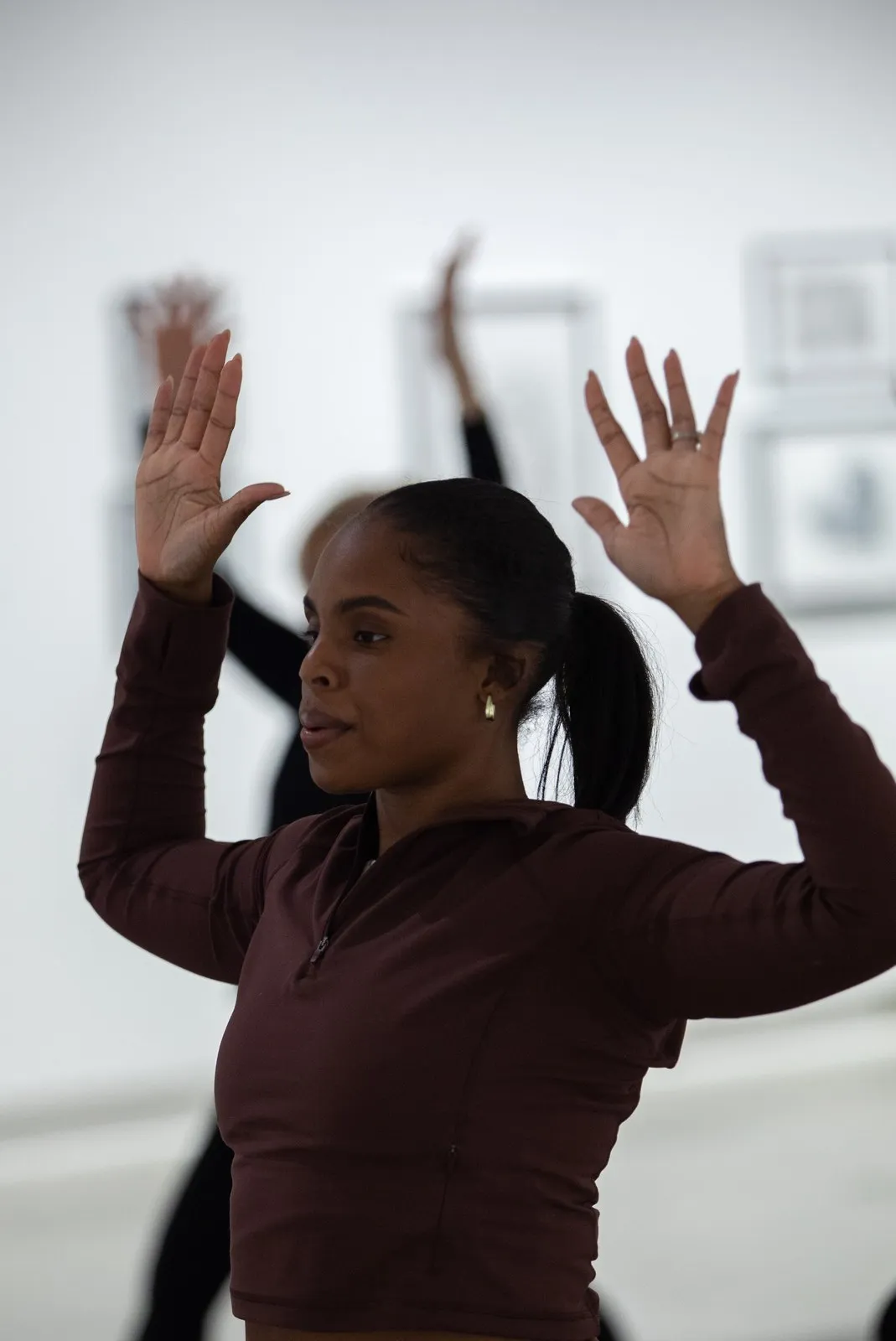 A practitioner moving through a flow with arms raised