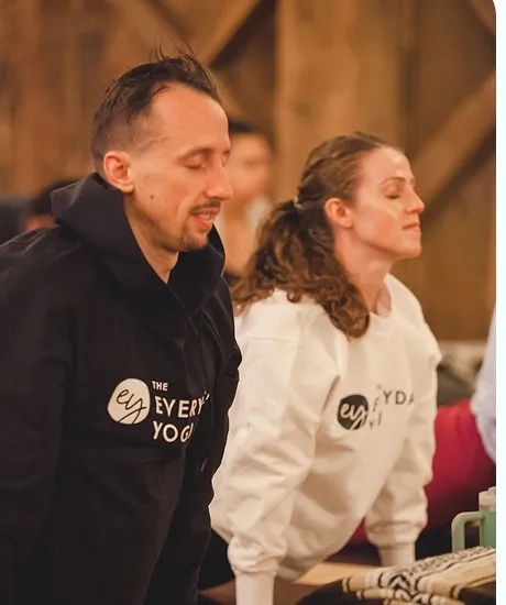 Two people in Everyday Yogi sweaters in quiet seated practice